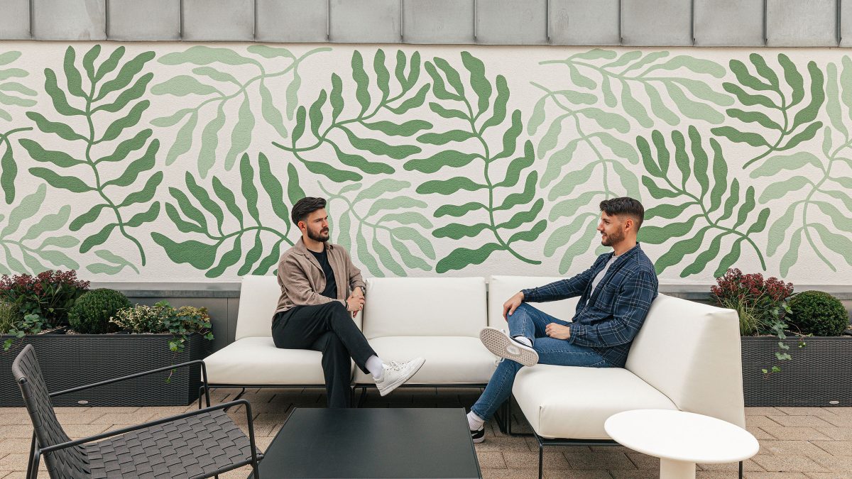 two-people-on-terrace-with-large-leaf-mural-at-mastercard-budapest-office